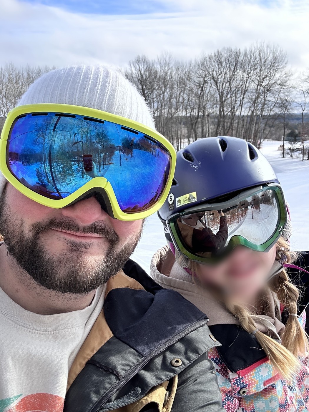 Kyle Joeckel on the mountain with goggles on, riding with his daughter